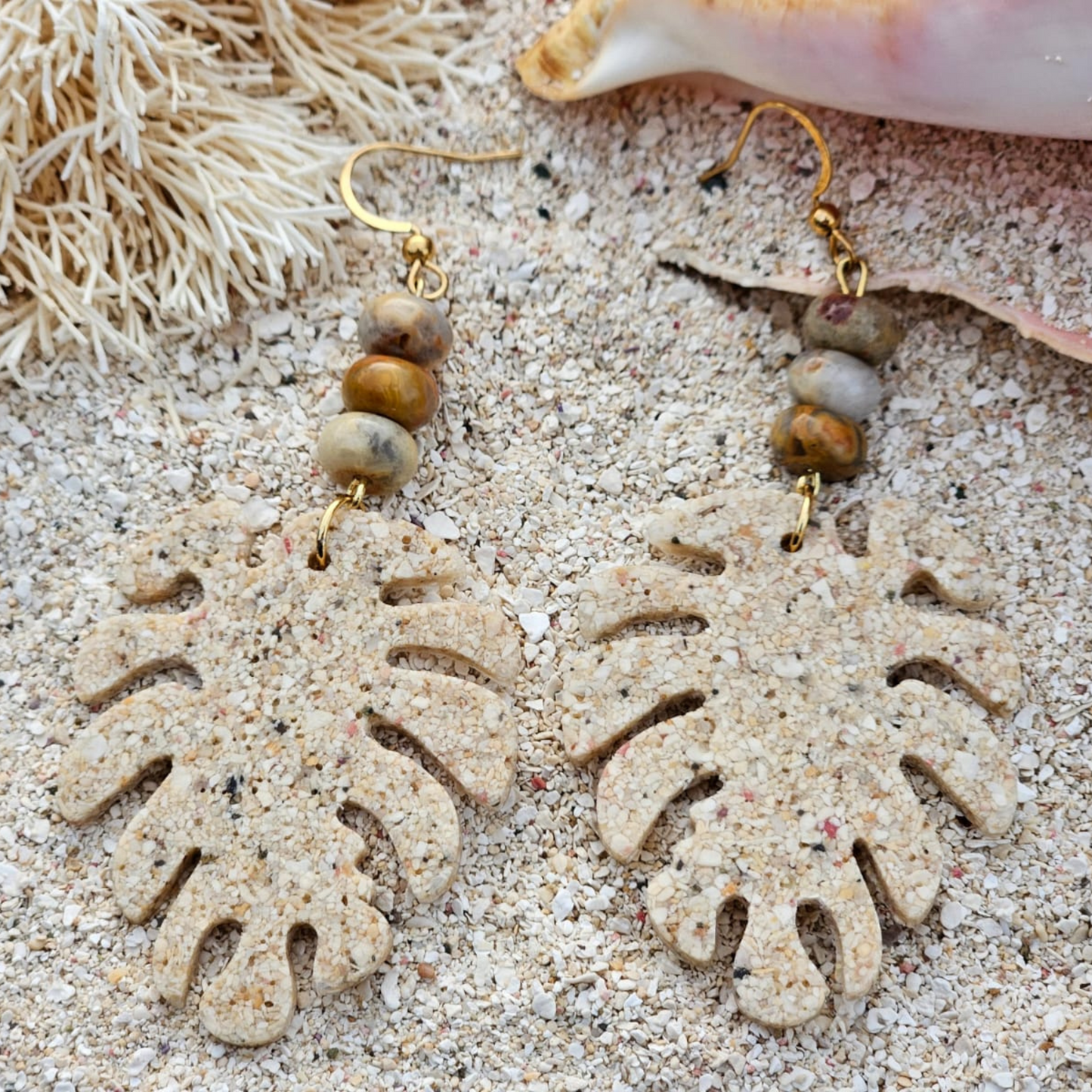 Leaf-shaped earring in beach sand